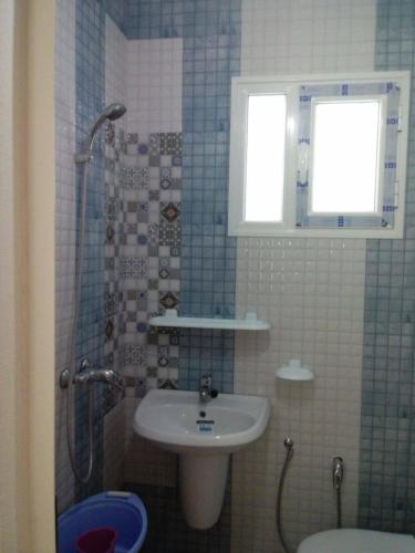 a bathroom with a sink and a shower with a window at Dar Si Lamin 2 in Kelibia