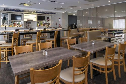an empty restaurant with wooden tables and chairs at Radisson Hotel Edmonton Airport in Leduc