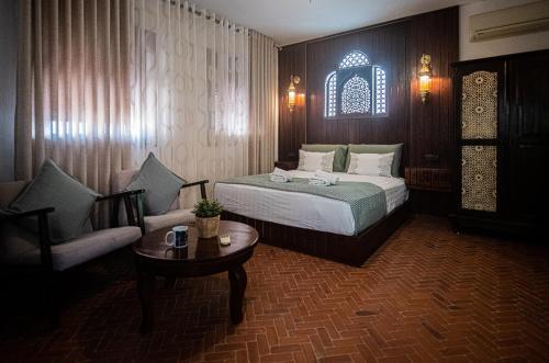 a bedroom with a bed and a table and a chair at Casa Bellavista Chaouen in Chefchaouen