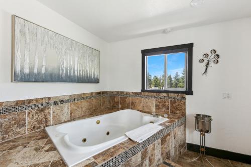 a bath tub in a bathroom with a window at Heavenly Inn Lake Tahoe in South Lake Tahoe