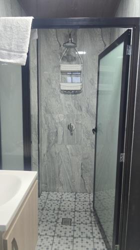 a bathroom with a shower with a glass door at mi casa tropical in Hacienda Santa Clara