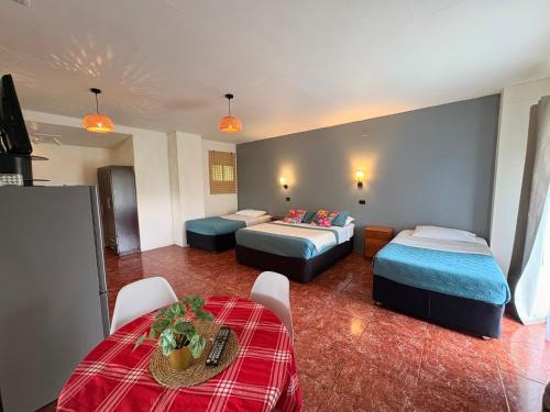 a hotel room with two beds and a table at Cabañas Honu Nui Inn in Hanga Roa