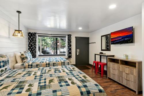 a bedroom with two beds and a couch and a desk at Heavenly Inn Lake Tahoe in South Lake Tahoe