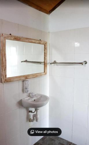 a bathroom with a sink and a mirror at Nora Cottage Natural in Batununggul