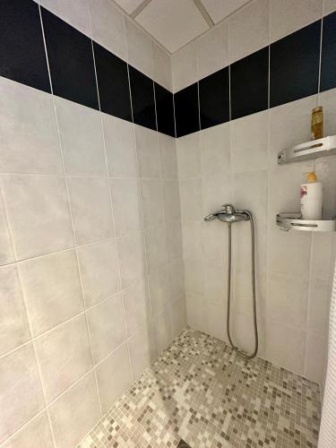 a bathroom with a shower with black and white tiles at The Rave in Sète