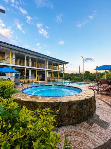 a resort with a swimming pool in front of a building at Finca Hotel Vista Palmar - Eje Cafetero in Quimbaya
