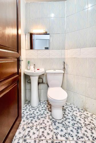 a bathroom with a toilet and a sink at BJ House in Douala