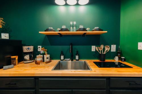a kitchen with a sink and a green wall at The Taoist 5min to Gorge with Private Cliffs in Rogers