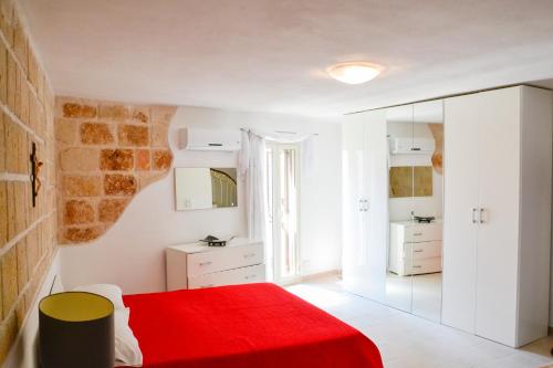 a bedroom with a red bed and a mirror at Dimora Arco Antico in Monopoli