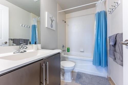 a bathroom with a sink and a toilet and a tub at Mississauga Downtown Condos in Mississauga