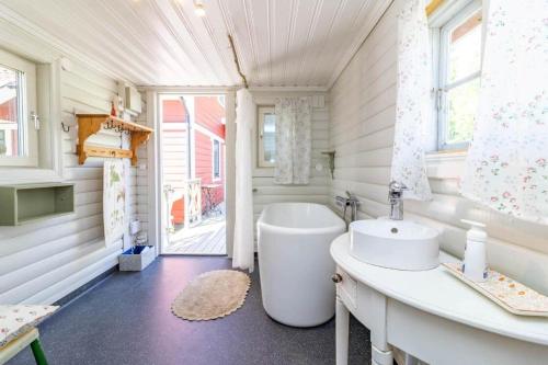 a white bathroom with a tub and a sink at VMA812-Kolsva-Lomstigen-7 in Kolsva