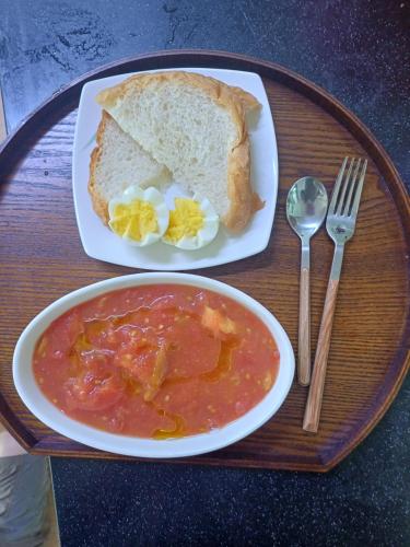 a plate of food with a bowl of soup and bread at Melodia Pension in Geoje