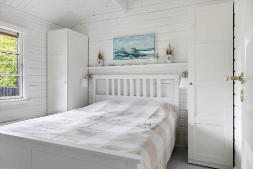 a bedroom with white walls and a white bed at TV1729-Jerup-Engdraget-16 in Bratten Strand