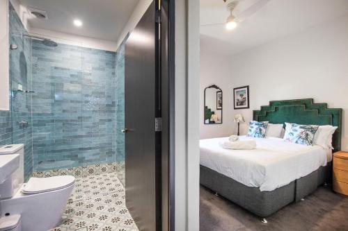 a bedroom with a bed and a glass shower at Imperial Hotel Paddington in Sydney