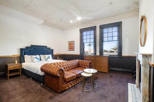a bedroom with a bed and a couch at Imperial Hotel Paddington in Sydney
