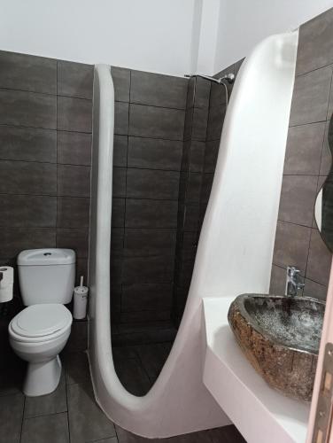 a bathroom with a toilet and a sink at Perissa Economy Rooms in Santorini