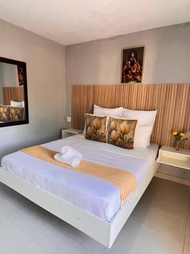 a bedroom with a large bed with a wooden headboard at Lamamie Lodge in Thohoyandou