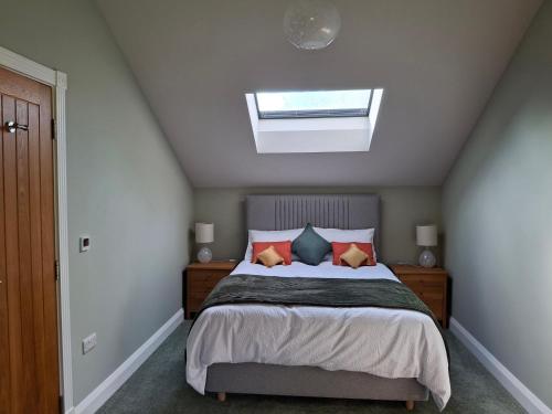 a bedroom with a bed and a skylight at The Old Saw Mill in Llangunllo