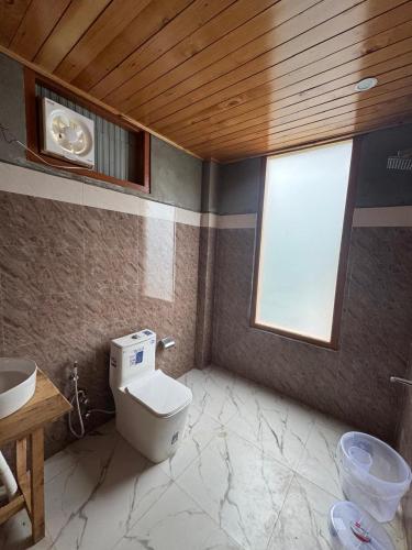 a bathroom with a toilet and a sink at the jibhi nest cottage in Mandi