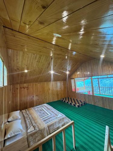 a large wooden room with a bed in a sauna at the jibhi nest cottage in Mandi
