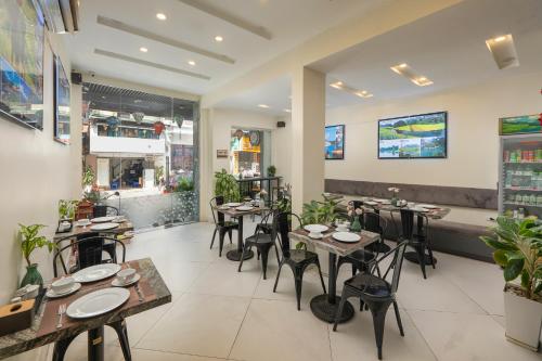 a dining room with tables and chairs in a restaurant at Queen Cafe Hostel in Hanoi