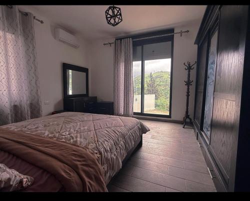 a bedroom with a bed and a large window at Casablanca chalet in Umm Nūwārah