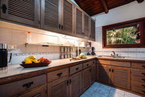 a kitchen with wooden cabinets and a bowl of fruit on the counter at Rancho del Lago in San Carlos de Bariloche