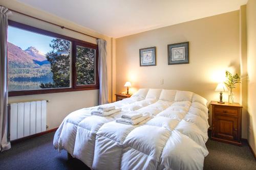 a bedroom with a large bed with a large window at Rancho del Lago in San Carlos de Bariloche