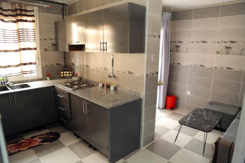 a kitchen with gray cabinets and a counter top at Golf paradis in Oran