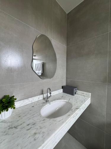 a bathroom with a sink and a mirror at Pousada 8 Mares in Arraial do Cabo