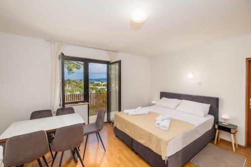 a bedroom with two beds and a table and chairs at Maja Apartments Malinska in Malinska