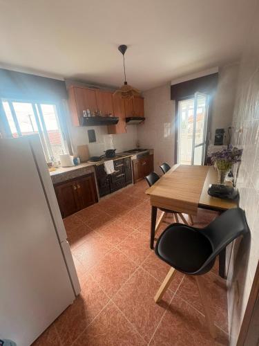 a kitchen with a wooden table and chairs in it at Casa do camiño in Villariño