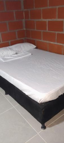 a bed in a room with a brick wall at Cabaña los villa in Necoclí