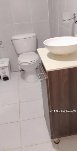 a bathroom with a white toilet and a sink at Cabaña los villa in Necoclí