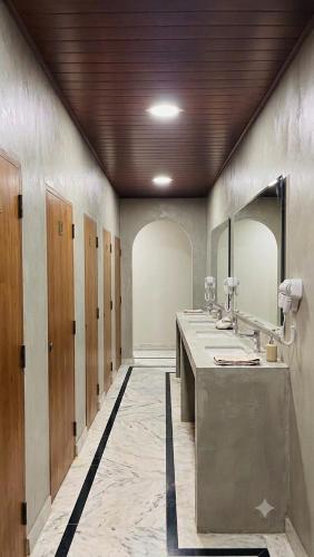 a bathroom with three sinks and two mirrors at Ceylora Resort in Sigiriya