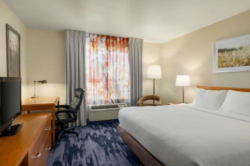 a hotel room with a bed and a desk and a television at Fairfield Inn & Suites by Marriott Springdale in Springdale