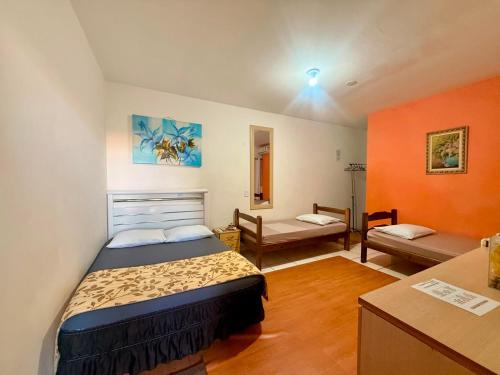a small bedroom with a bed and a desk at Pousada Anhanguera in Ribeirão Preto