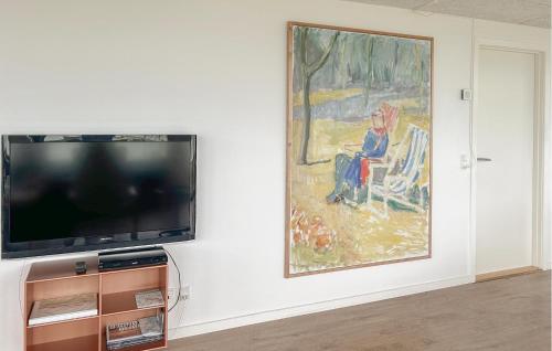 a flat screen tv sitting on a wall next to a painting at Amazing Home In Augustenborg With Sauna in Augustenborg