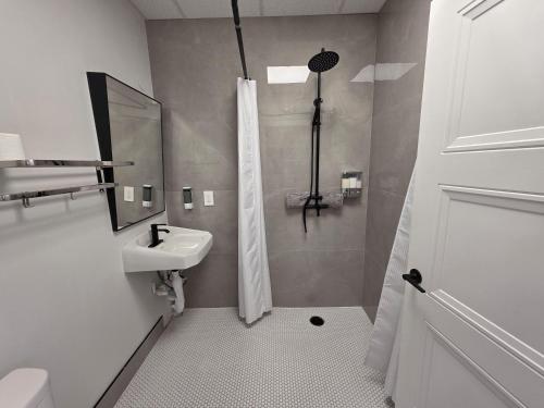 a white bathroom with a sink and a shower at PeachView Studio 103 in Peachland