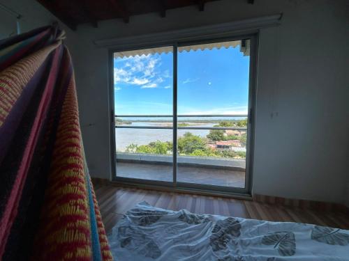 a bedroom with a large window with a view of the water at Villa Magdalena y Puerto Perales in La Piedad
