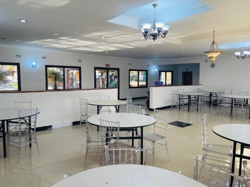 a dining room with tables and chairs and a bar at Mana Nest Lodge in Choma