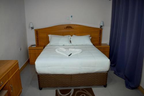 a bedroom with a bed with a heart on it at Mana Nest Lodge in Choma