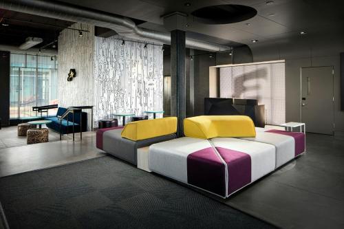 a bedroom with a bed and a table and a piano at Aloft by Marriott Arundel Mills BWI Airport in Hanover