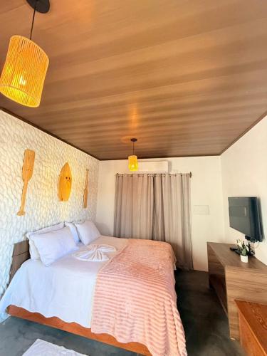 a bedroom with a large bed and a tv at Villa Fênix Suítes in Barreirinhas