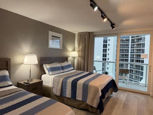 a hotel room with two beds and a window at Ocean front Condo with balcony on the beach in Sunny Isles Beach