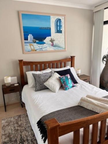 a bedroom with a bed with a painting on the wall at Seaside Escape Rockingham in Rockingham