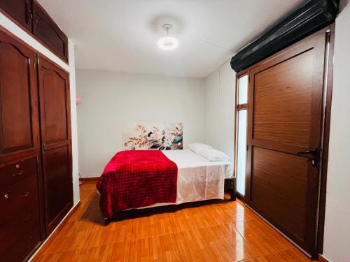 a bedroom with a bed with a red blanket at Hospedaje el Trujillanito in Víctor Larco Herrera