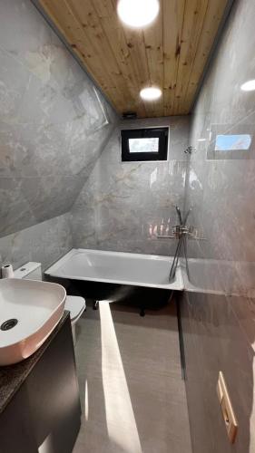 a bathroom with a tub and a toilet and a sink at Magnolia Cottage in Ts'ikhisdziri