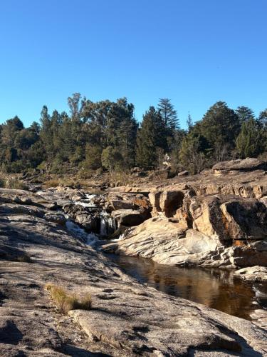 a river with rocks and trees in the background at Cabaña Camping Cabalango in Cavalango
