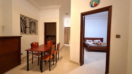 a room with a table and a bedroom with a bed at Adelhouse in Saint-Louis
